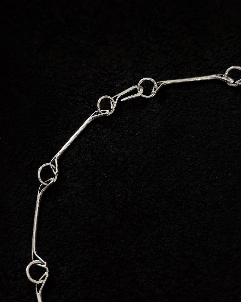 Close-up of handcrafted 925 sterling silver necklace with jawbone-inspired sculptural form