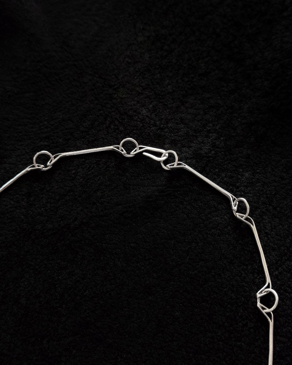 Close-up of handcrafted 925 sterling silver necklace with jawbone-inspired sculptural form